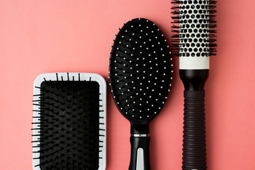 Used Hair brush tools on pink or coral background with copy space. Beauty fashion, hair care...