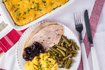 Meal plate for holiday with smoked pieces of turkey and two sides.