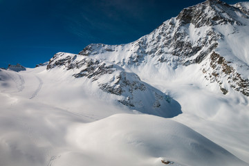 Aerial view of landscape in the Swiss alps with tourers and their tracks