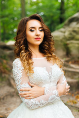 beautiful bride in her wedding dress embraces herself and closed