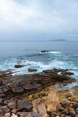 ROCAS EN LA ORILLA DE LA COSTA DE GALICIA Y HORIZONTE DE CIELO CON BRUMA