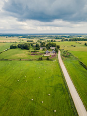 Fototapeta na wymiar Aerial Photo of old Farmer houses with Road by its Side and Agriculture Fields Around it in Early Spring on Sunny Day