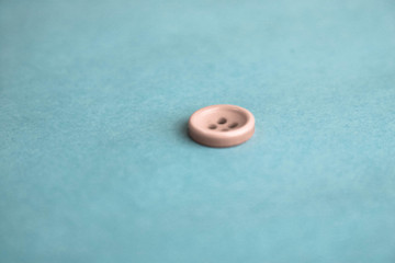 Beautiful texture with a round white button for sewing, needlework. Copy space. Flat lay. Blue background