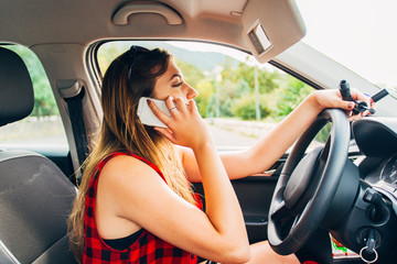 Young beautiful reckless woman using smartphone while driving car