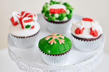 Seasonal festive christmas mini dessert cupcakes in traditional red green decorative symbols elements