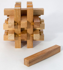 Three dimensional wooden puzzle with last piece.