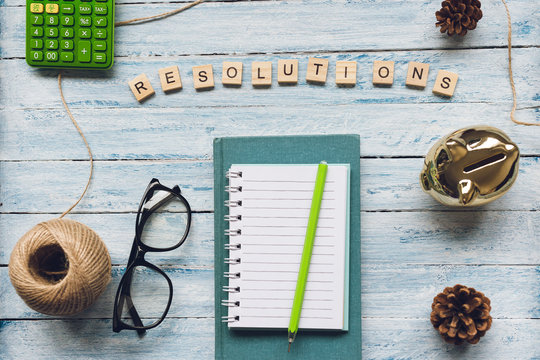 RESOLUTIONS word and a notepad on a light background