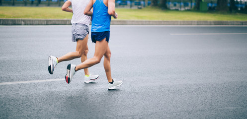 Fototapeta premium Marathon runner legs running on city road