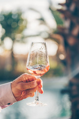 Swirling glass of rose wine at wine tasting. Concept of rose wine