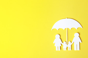 Paper silhouette of family under umbrella and space for text on color background, top view. Life...