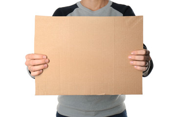Woman holding piece of cardboard on white background, closeup. Space for text
