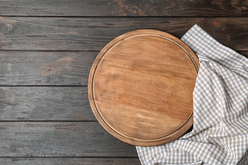 Fabric napkin with serving board and space for text on wooden background, top view