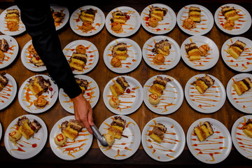 Garçom montando os pratos de sobremesa com sorvete e bolo