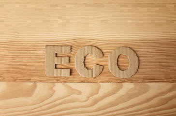 Word "Eco" made of cardboard letters on wooden background, top view