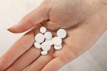 Woman holding many pills in hand, closeup view