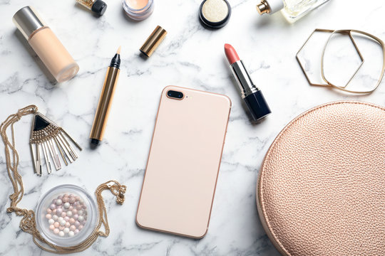 Flat lay composition with lipstick and smartphone on marble background