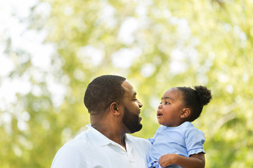 African American father hugging and holding his little girl.