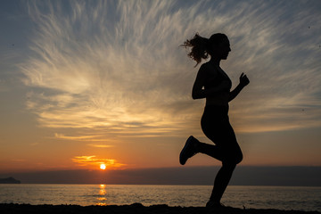 young woman does exercise at sunrise