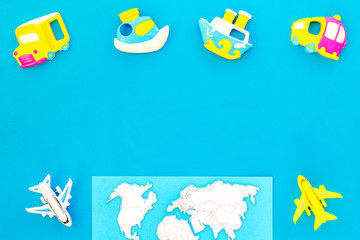 accessories for treveling with children, map and toys on blue background top view mock-up