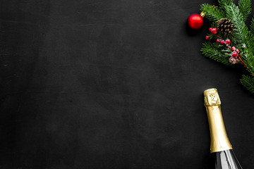 New year and Christmas party with spruce, champagne bottle on black background top view space for text