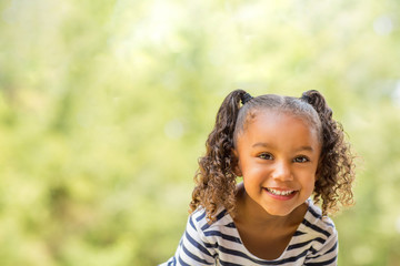 Cute mixed race little girl laughing and smiling. - Powered by Adobe