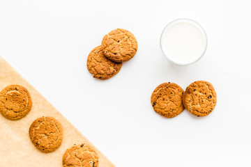 Drink milk with cookies concept. Cup of milk and fresh homemade cookies on white background top view pattern