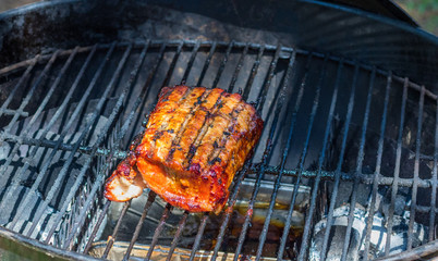 Red meat slow roasting in an outdoor kettle oven image with copy space