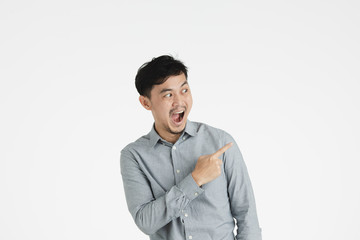 Asian young man pointing at something imaginary