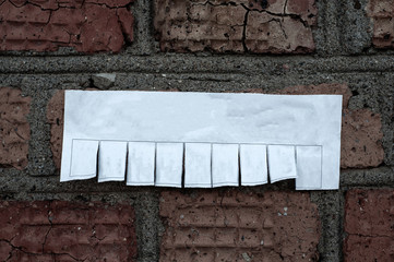 Paper advertisement without text pasted on the old brick wall