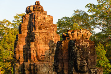 Stone faces in Bayon, Angkor Thom temple, selective focus sunset light. Buddhism meditation concept, world famous travel destination, Cambodia tourism.