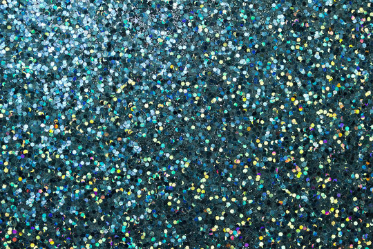 Colorful macro abstract background of glitter confetti in shades of turquoise blue