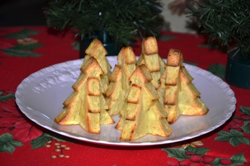 Plat de pommes-frites découpées en forme de sapins de Noël sur nappe de fête
