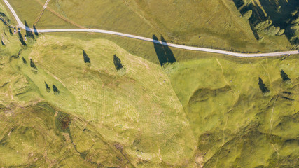 A drone vertical perspective of the meadows at high altitudes, forming soft hills. Dolomites, Alta Badia, Sud Tirol, Italy