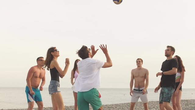 young people group have fun and play beach volleyball at summer day