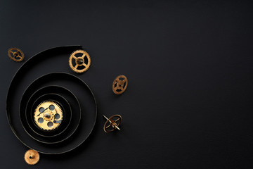 Gears on a black background.Broken mechanism.Spring from wall clock