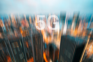 5G on a motion blurred city skyline illuminated at dusk