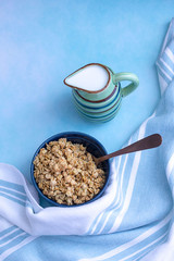 Granola in a bowl with milk jar on the side