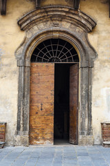 Wooden arch door on medieval brick building in Siena. Italy