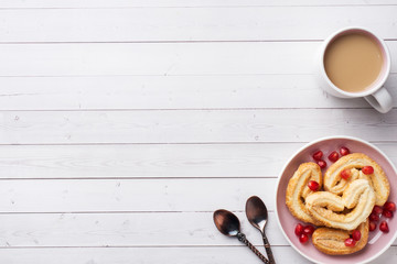 Valentine's day Breakfast concept. Cup of coffee and a cookies hearts on a white table. copy space, flat lay.