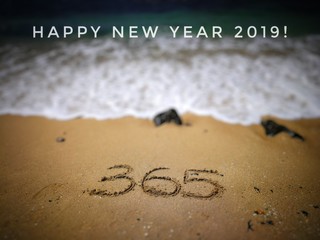 Text label with blurred background of sandy beach, Happy New Year 2019