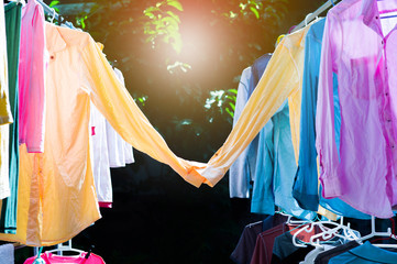 Colorful wet clothes hanging on the steel clothesline for drying by the heat of sun. Sweet couple of shirts concept. Happy valentines day