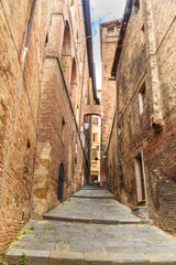 Medieval narrow street in Siena, Tuscany, Italy.