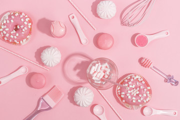 Kitchenware and tools, pastry and sweets on a pink background. Top view.