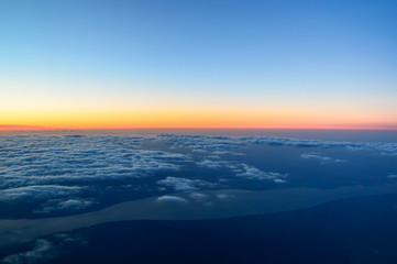 Fototapeta na wymiar above the clouds, a beautiful dawn at an altitude of 10,000 meters, the Volga River