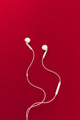 White earphones on red background