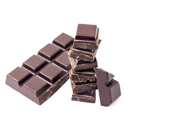Chopped chocolate cubes, pieces of dark chocolate bar isolated on white background