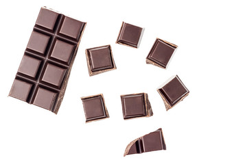 Chopped chocolate cubes, bitter, dark chocolate bar isolated on white background, top view