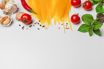 Pasta Spaghetti with ingredients for cooking pasta on a white background, top view.