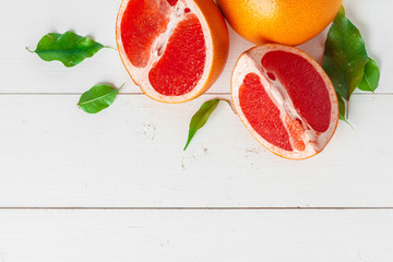 Grapefruit with slices on a wooden table.