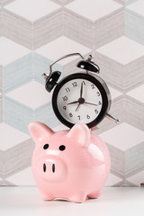 Alarm clock and piggy bank concept for saving time